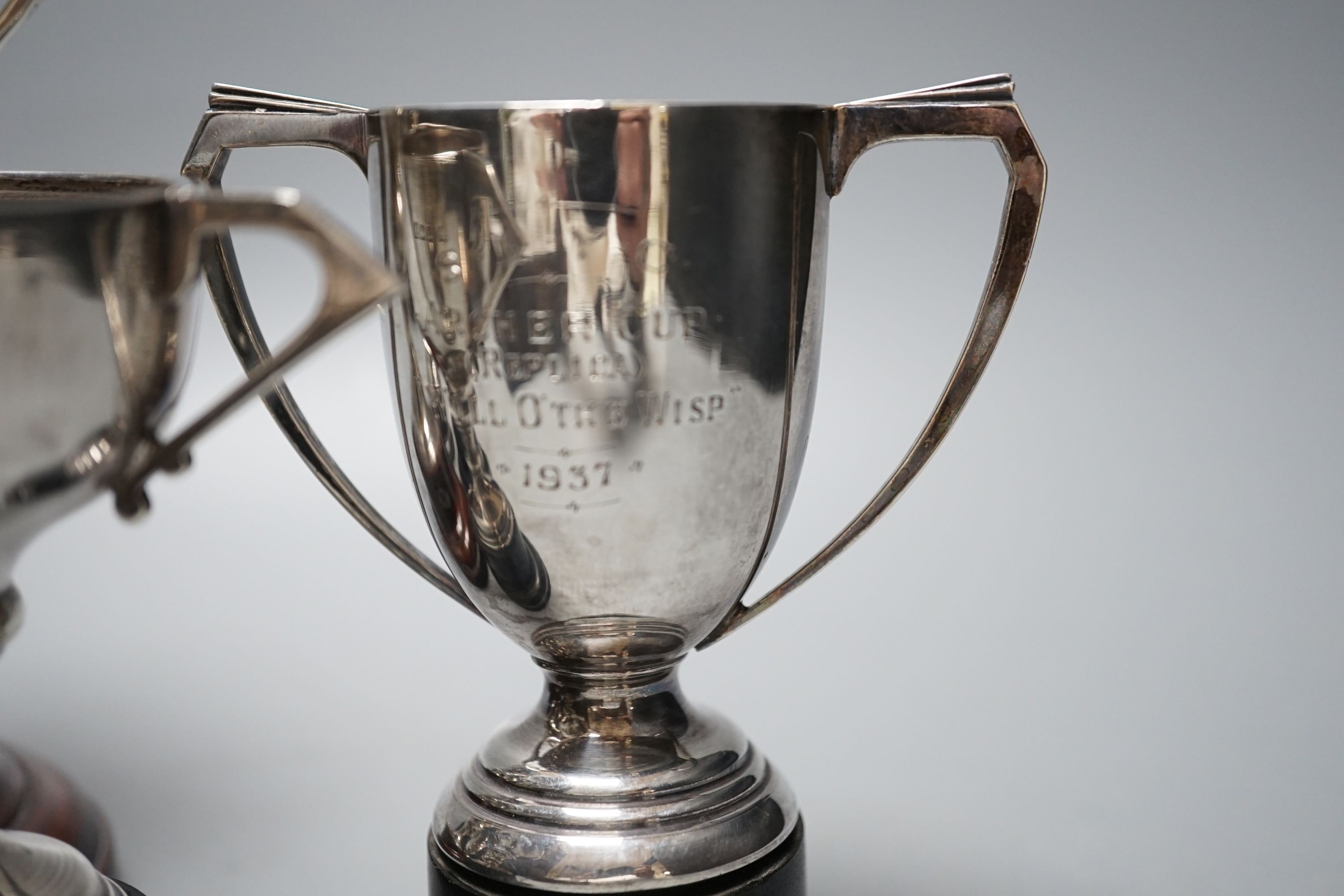 Five assorted 1920's/1930's silver two handled presentation trophy cups, all with engraved inscriptions and all with stands, largest 11.8cm.